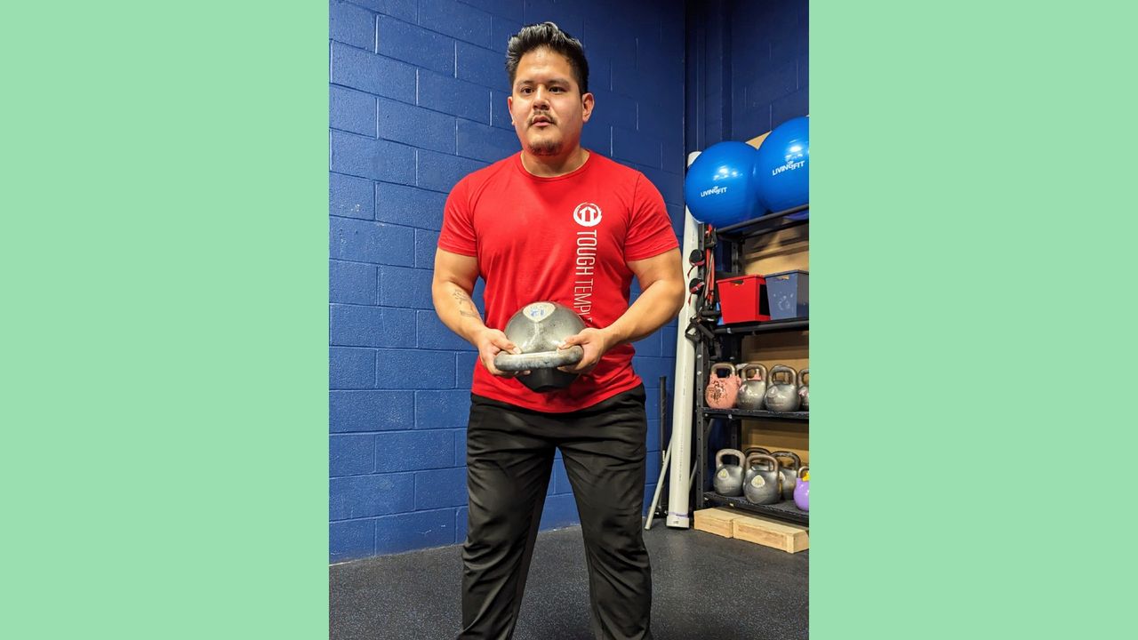 Gio Amatore with kettlebell pressed to stomach standing up