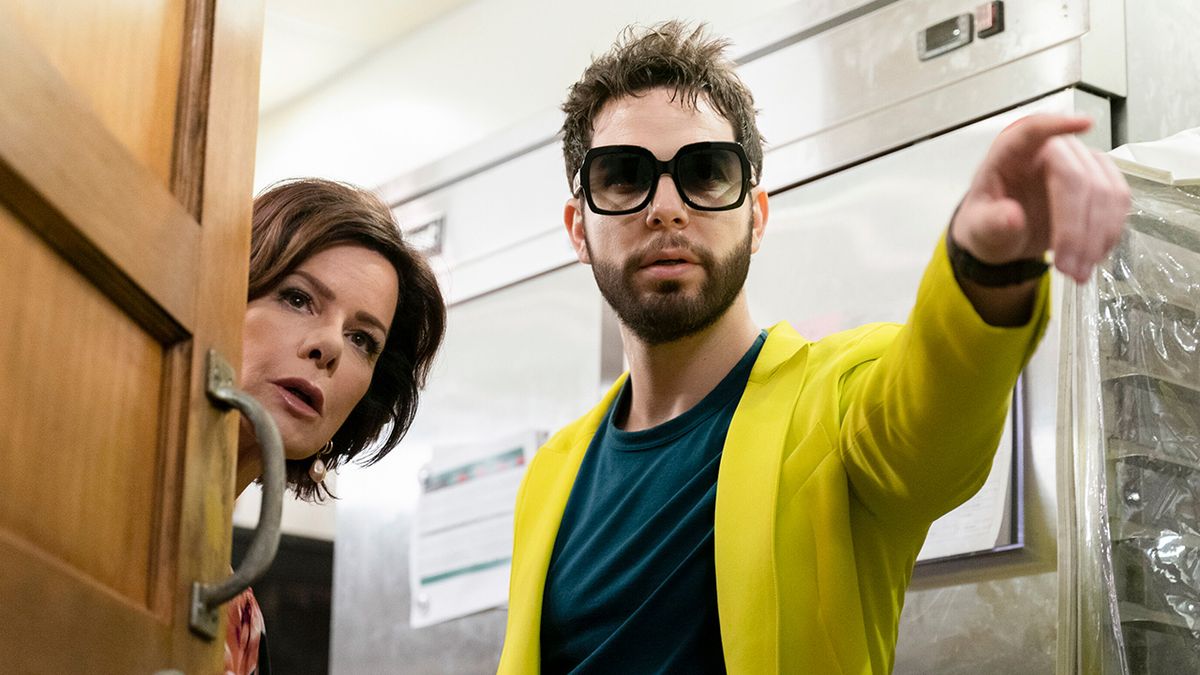 Marcia Gay Harden and Tyler Astin peering around a door in So Help Me Todd.