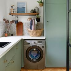 Green utility room with silver washing machine 