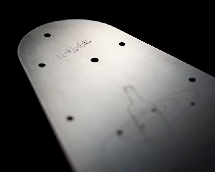 a triangular metal plate with curved corners and an etching of an equation onto the surface.