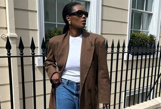 best elevated basics shown in a photo of a woman wearing a brown blazer over a white t-shirt with denim shorts