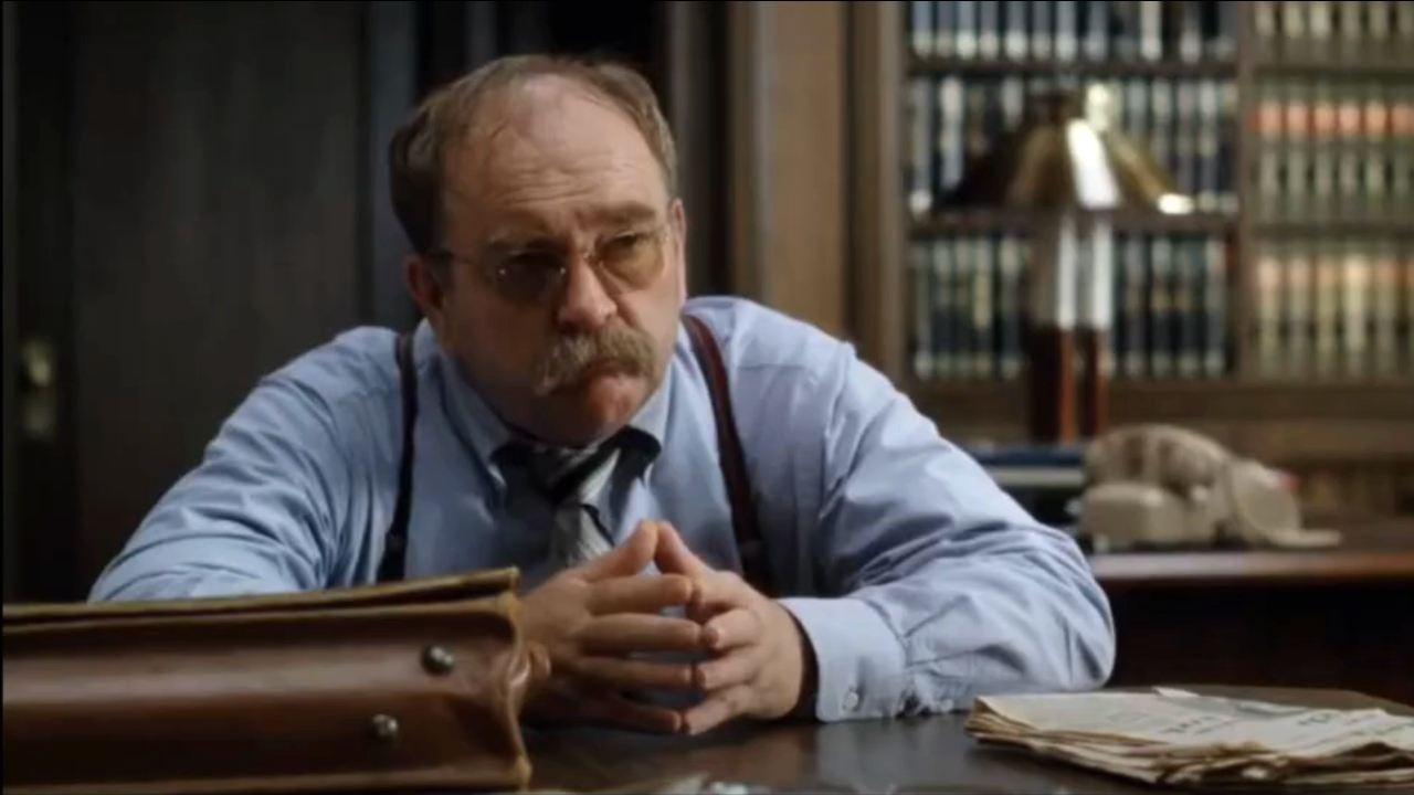 Wilford Brimley sits with his hands folded at a table in Absence of Malice.