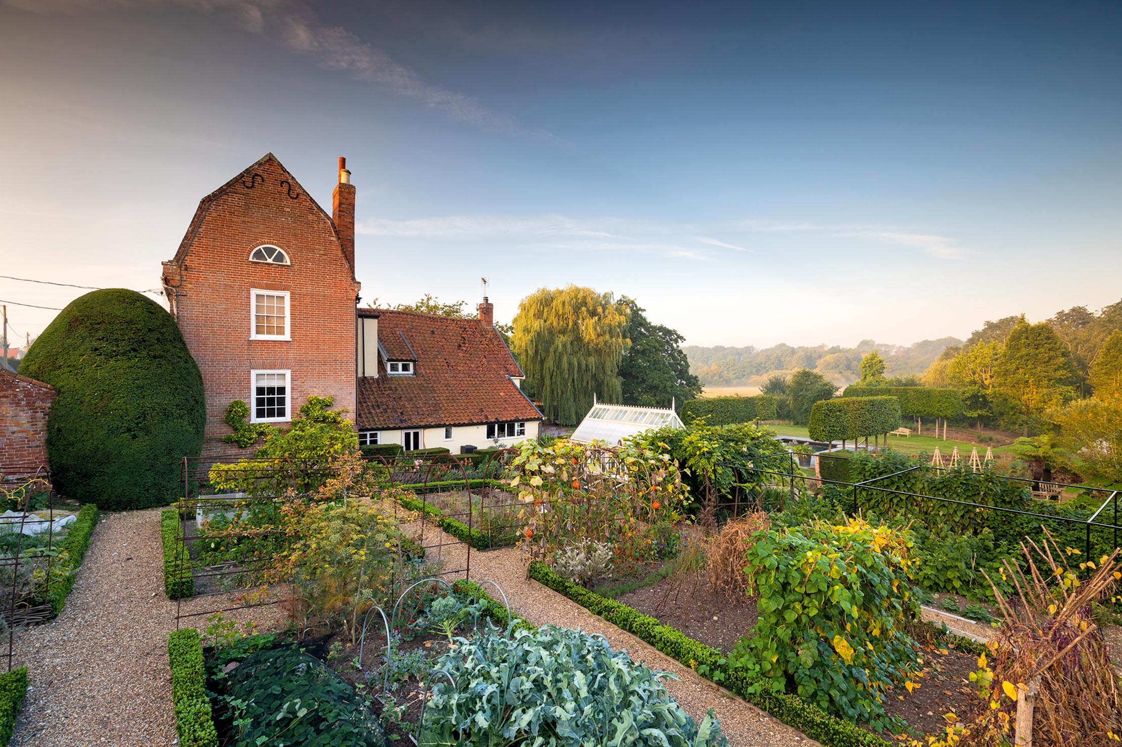 View from within formal walled vegetable garden to Mansard House and garden beyond in garden designer Thomas Hoblyn&#039;s own garden, Suffolk. ©Richard Bloom