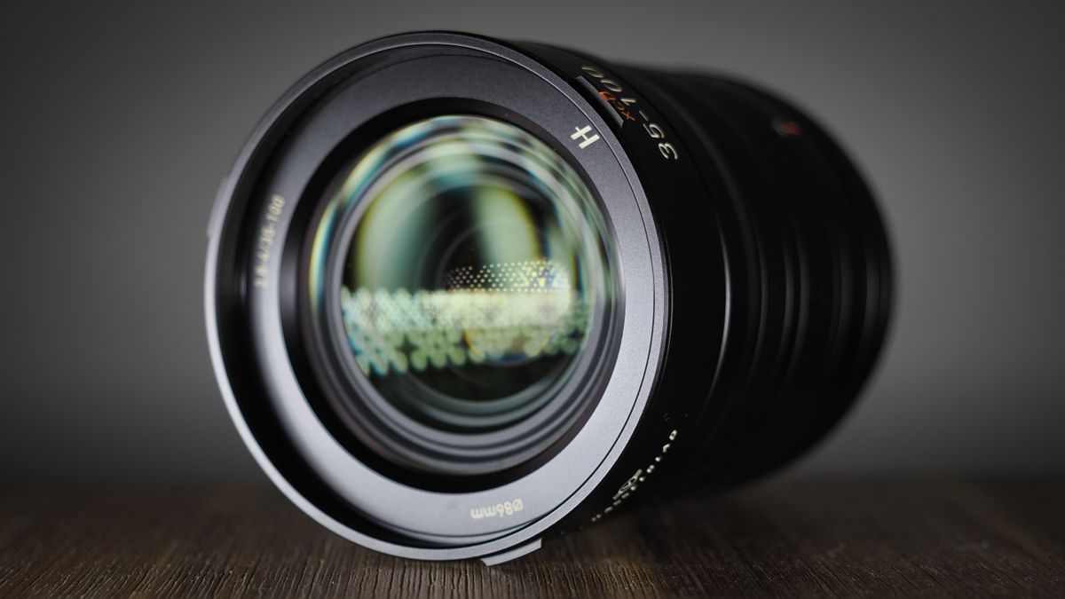 Hasselblad XCD 35-100E lens on a wooden surface in a moodily lit environment