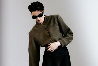 H&M green shoulder-pad jacket with a black pencil skirt and sunglasses