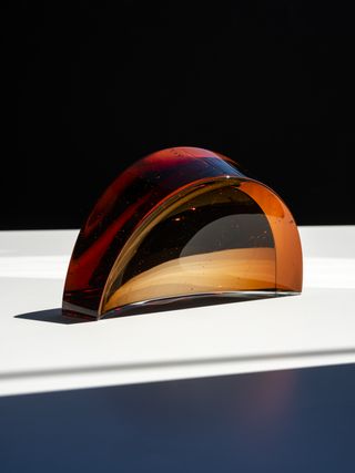 Amber coloured semi circular glass sculpture