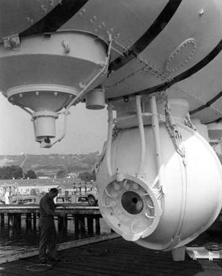 A close up view of the front of Trieste's pressure sphere, showing plexiglass window and instrument leads. The photo was taken circa 1958-59, shortly after Trieste was obtained by the Navy.