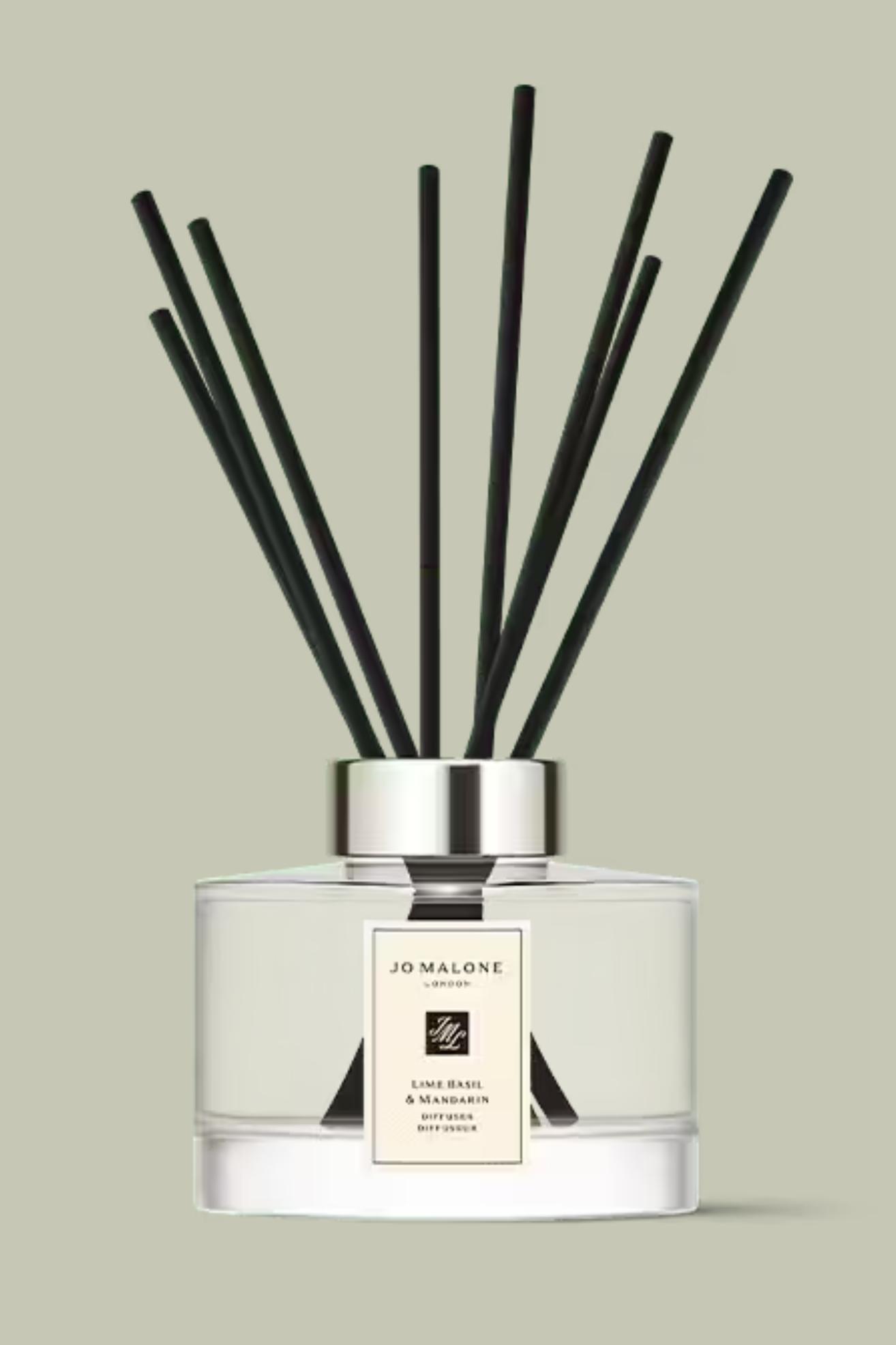 A glass reed diffuser with black reeds