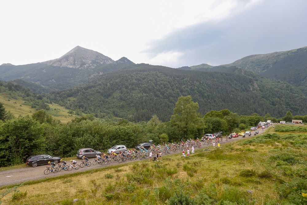 The peloton rides through the mountains during stage 12.
