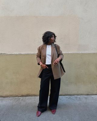 woman in beige blazer and black jeans