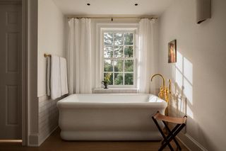 A neutral bathroom with brass accents