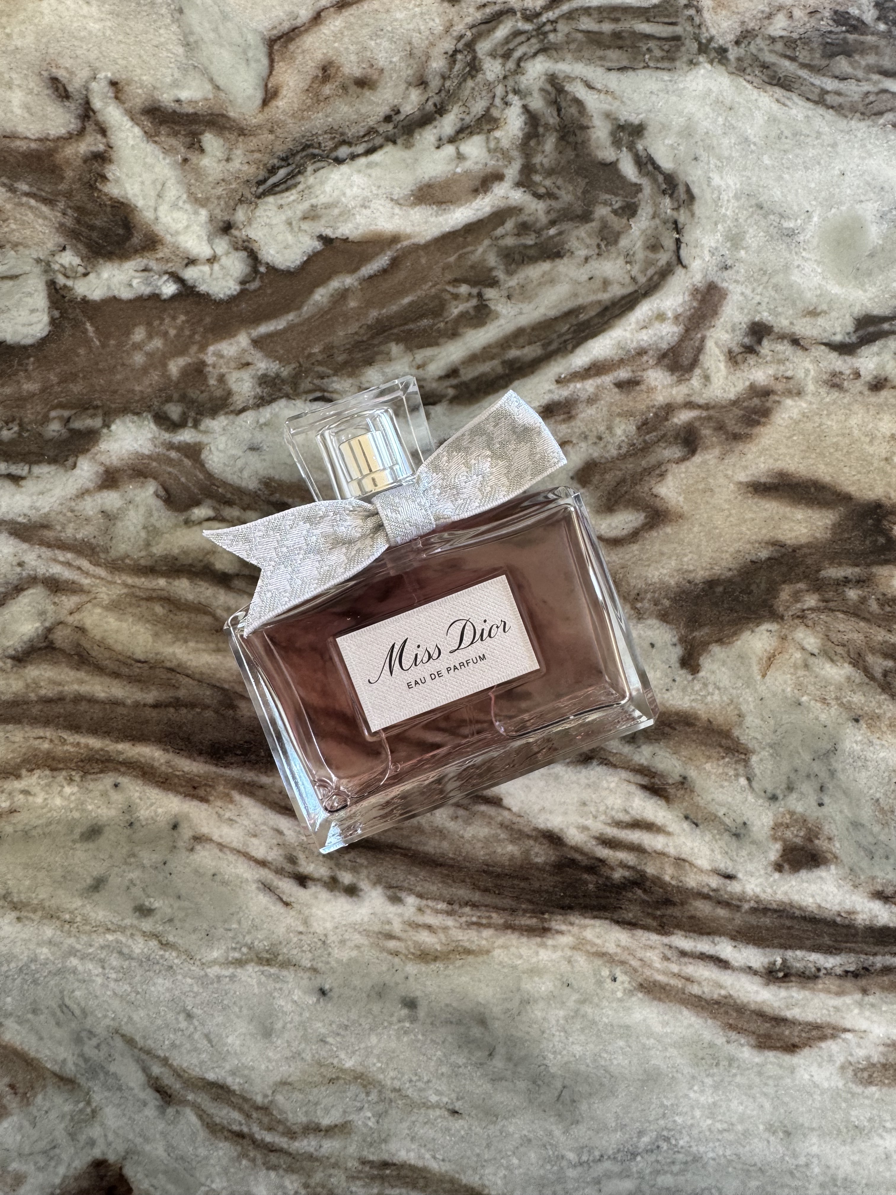 A bottle of Dior Miss Dior Eau de Parfum 2026 on a marble table