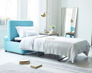Blue bed in a bundle to transform a lounge into a pop-up guest room.