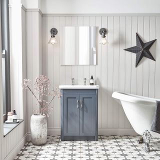 White bathroom with blue grey vanity and patterned tile floor