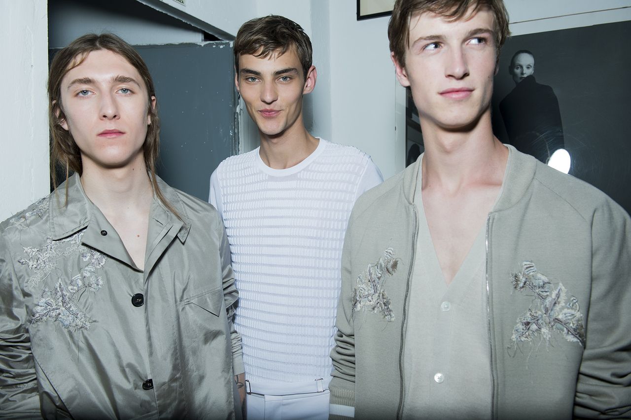 Three male models wearing clothing by Pringle of Scotland in light shades.