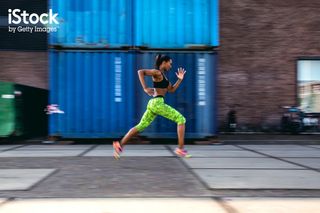 Woman running through urban environment
