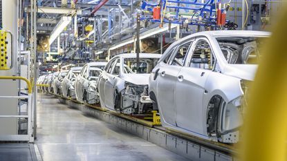 Row of cars in production line in a factory.