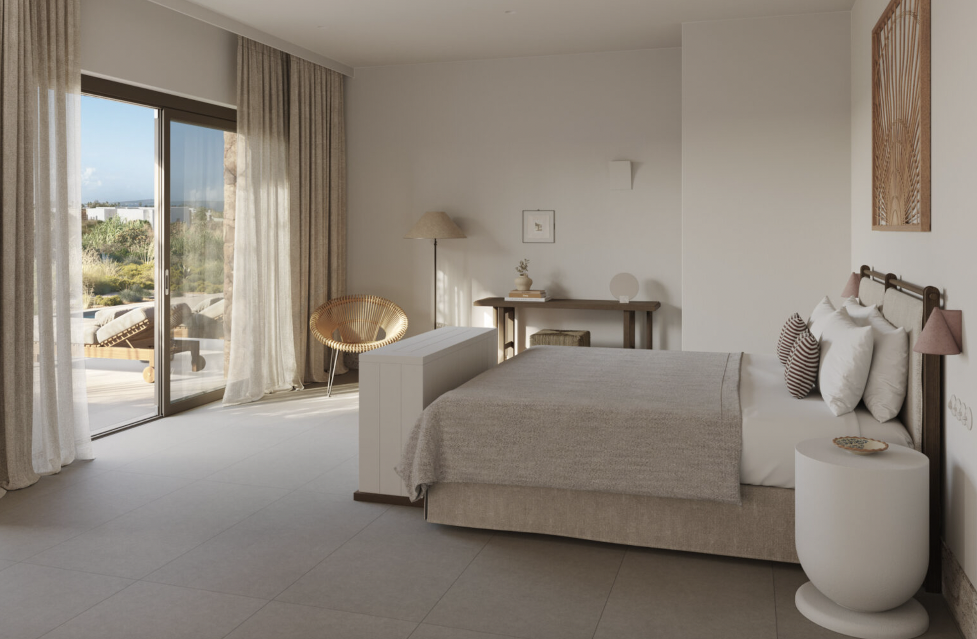 A neutral toned hotel bedroom with the bed facing out to the new out of the sliding doors, there is an artwork above the headboard, stone coloured floor tiles and a desk on the far right wall.