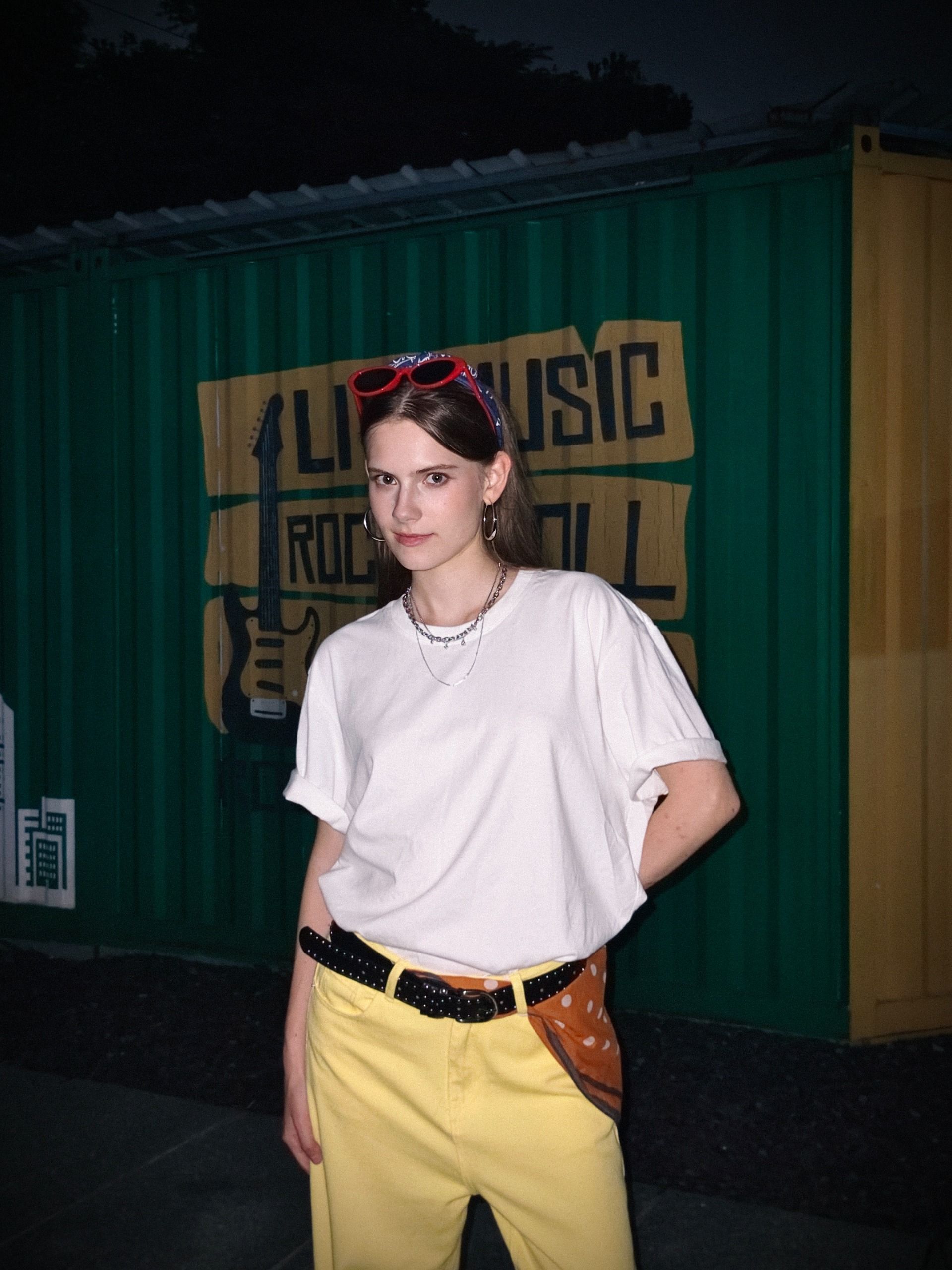 A woman posing for a photo lit by a bright flash