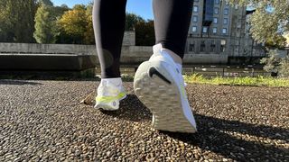 Woman's feet wearing Nike Infinity Run Flyknit 4 road running shoes - rear view