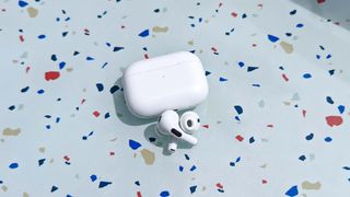 Apple AirPods Pro 2 with charging case placed on a table outside