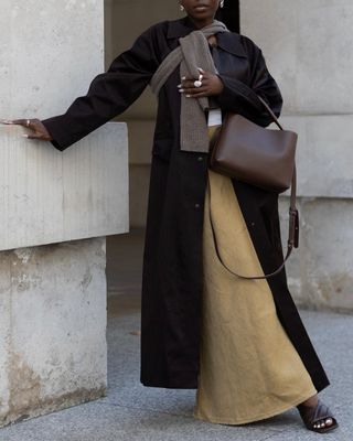 @daniellejinadu wearing a suede skirt with a long coat