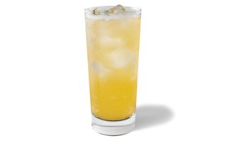 Vibrant yellow drink of Starbucks Lemon Iced Tea in a tall glass topped with ice