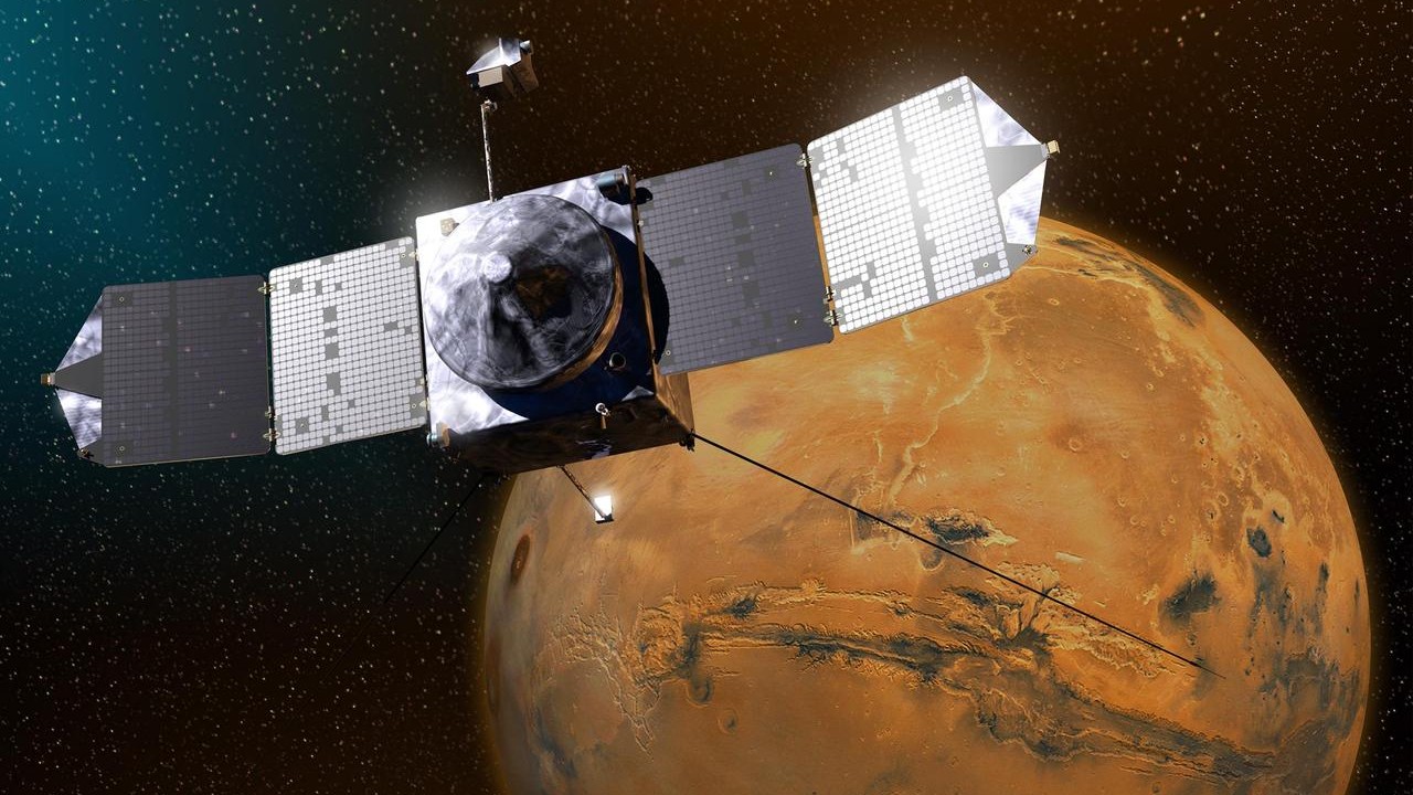 An illustration of a spacecraft with solar panels floating in front of a red planet