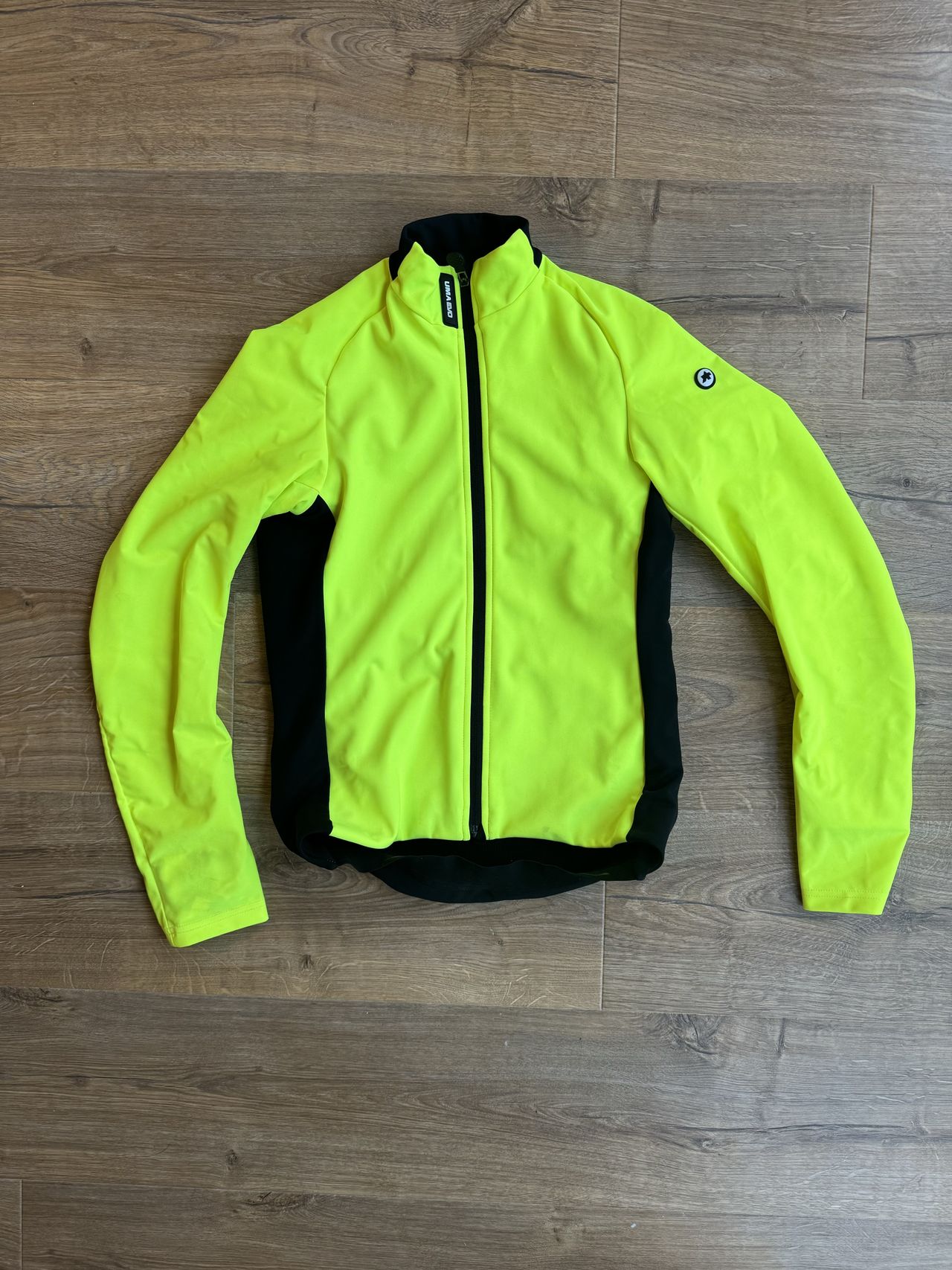 A flay lay of a bright yellow jacket on a floor