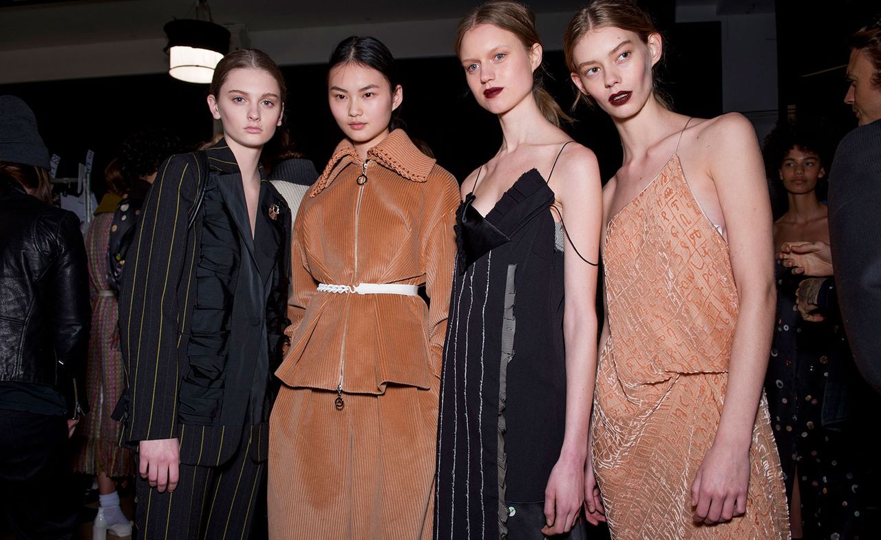 4 Models in black pin stripe and burnt orange dress and dress suit