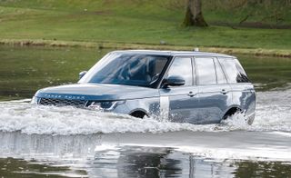 The Range Rover PHEV plug-in hybrid electric driving through water