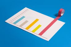 financial chart on blue background with different colored tape and red tape breaking above the top 