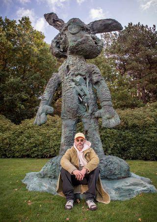Daniel Arsham sat in front of sculpture of rabbit