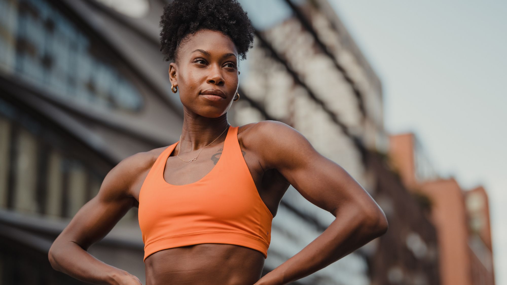 A woman stood with her hands on her hips in matching orange gymwear