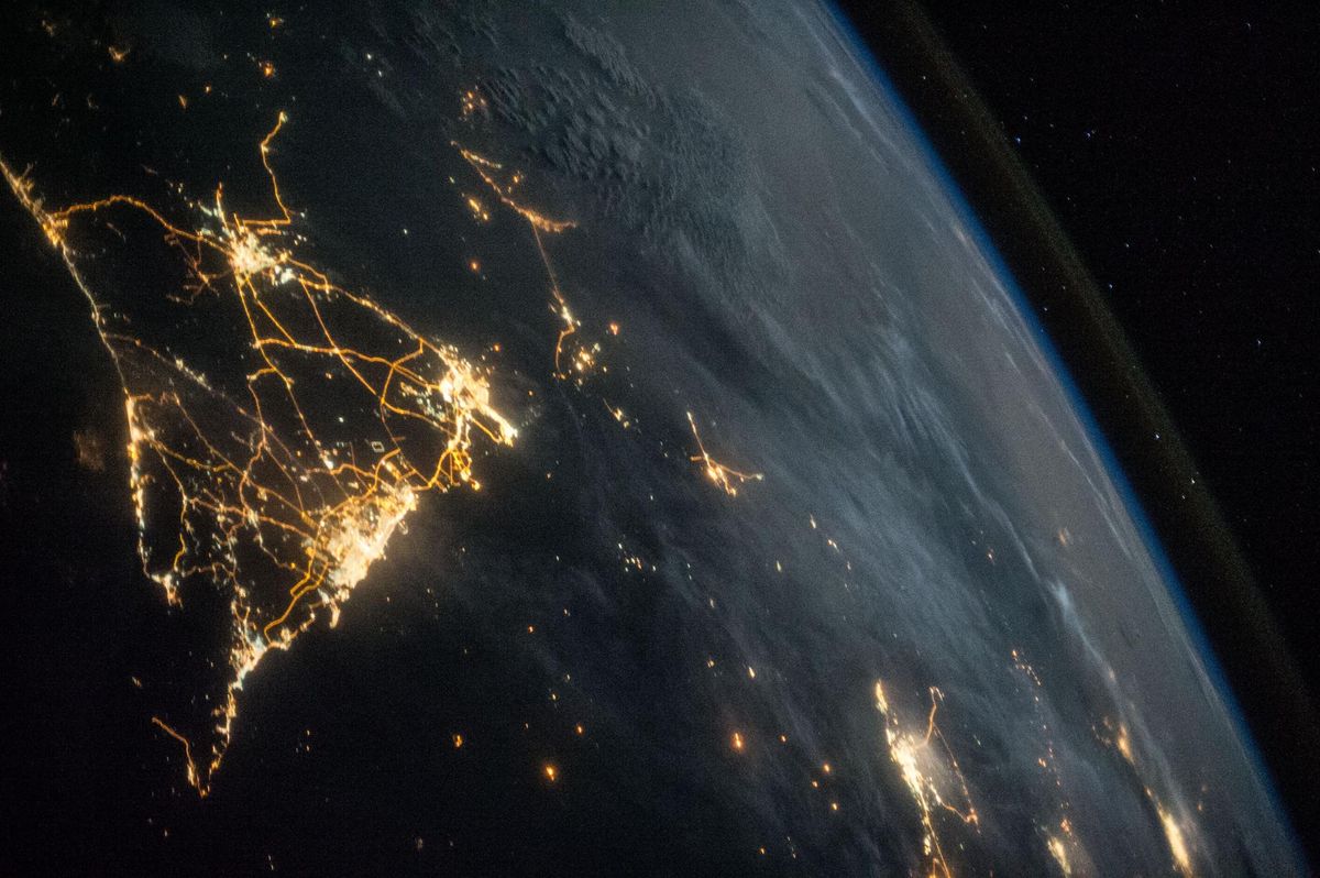 The International Space Station flies over a city at night. Human activity may be pushing the climate beyond a &#039;tipping point,&#039; a new report suggests.