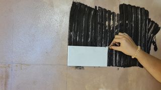 Applying a tile to a wall
