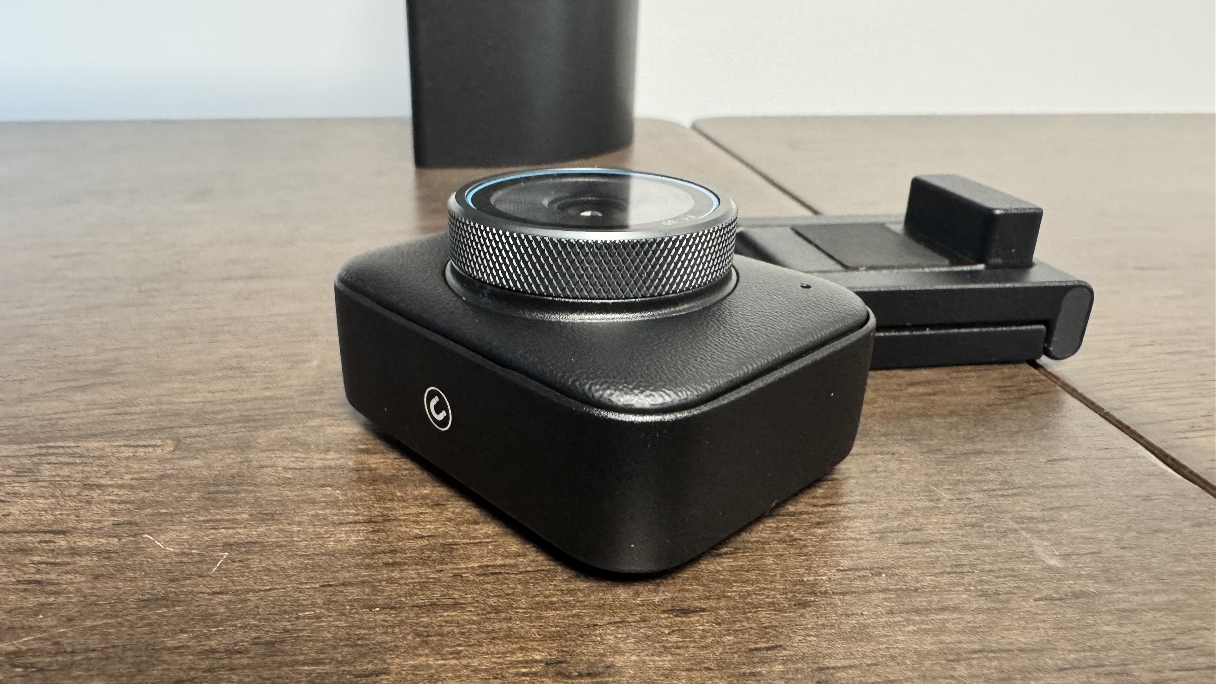 The Yololiv YoloCam S3 4K webcam from the bottom, next to its magnetic stand on a wooden table