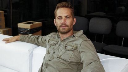 Paul Walker sitting on a white sofa