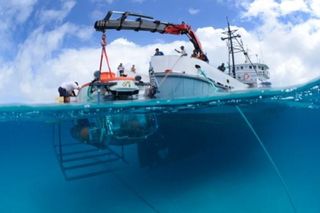 The "Curasub" submarine, a submarine of the Curaçao Sea Aquarium that can descend nearly 1,000 feet undersea, immersed in water by the research vessel Chapman. 