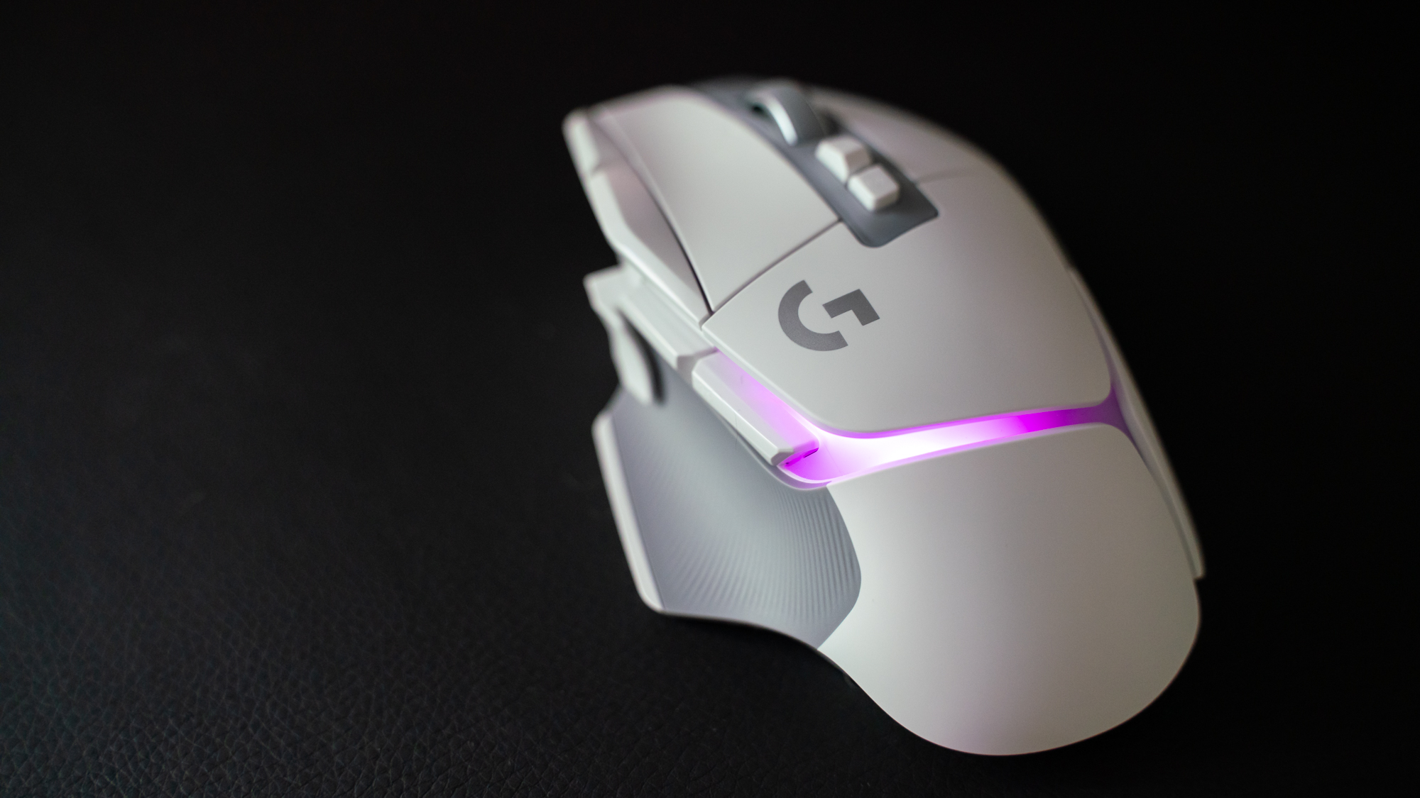 En gaming-mus av typen Logitech G502 X Plus på en matte av imitert lær.
