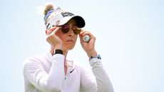 Nelly Korda putting on a pair of sunglasses during the Lotte Championship