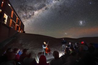 The world-renowned cellist Yo-Yo Ma treats astronomers to a starlit performance at the Paranal Observatory in the Atacama Desert of northern Chile. For this exclusive concert on May 1, 2019, Ma requested to play in a dark-sky site under the shimmering band of the Milky Way galaxy. To the right of the Milky Way are two of our galactic neighbors known as the Magellanic clouds, which are glowing through the subtle red and green airglow above the horizon.