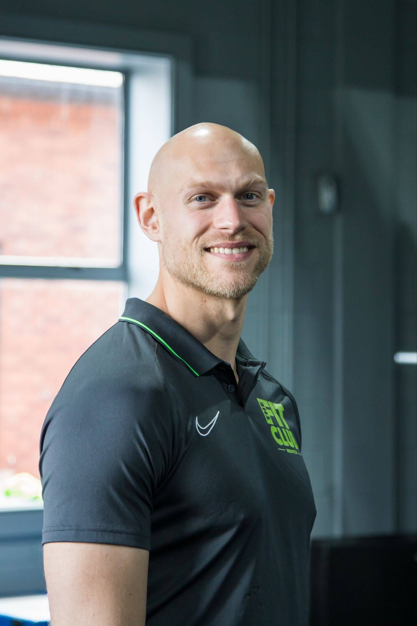 Man in sports polo smiles at camera