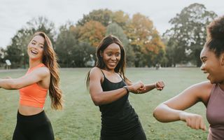 Three young women working out in the park as a natural remedy for PMT