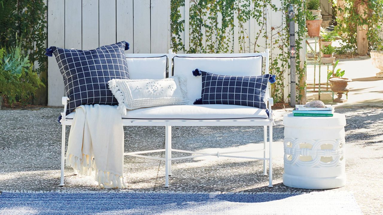 A decorative outdoor bench on a gravelled patio