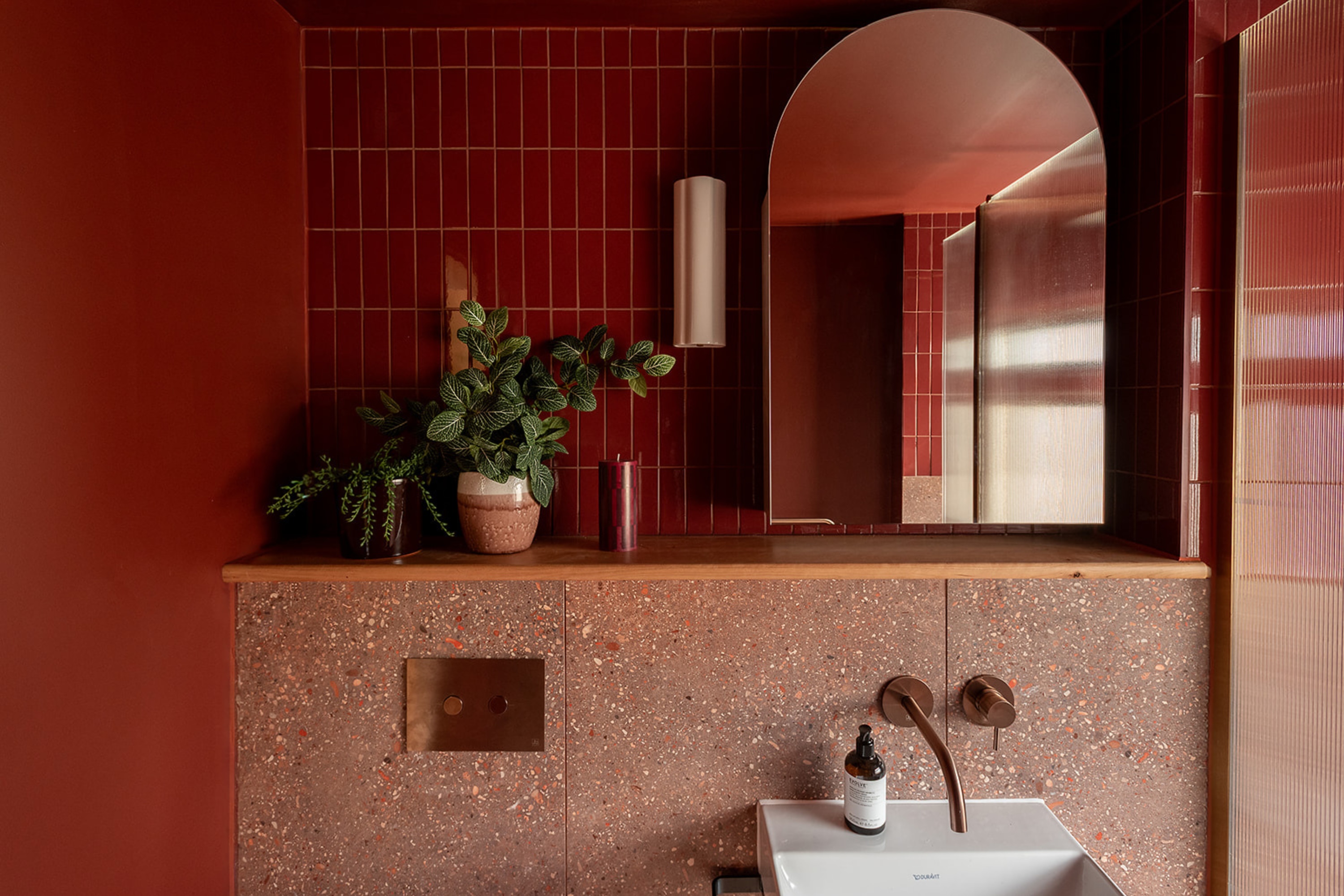 Rust and clay pink bathroom with terrazzo tiles by Studio Milne