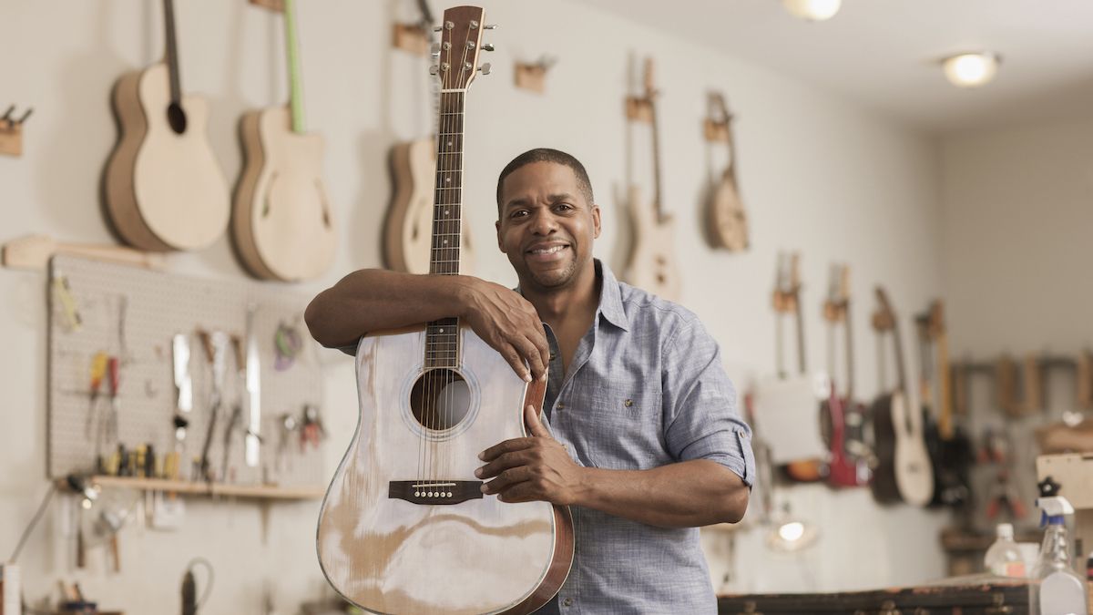 Man in a guitar shop holding an acoustic guitar