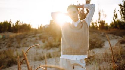 A woman on the beach in autumn, wearing a beige knitted jumper