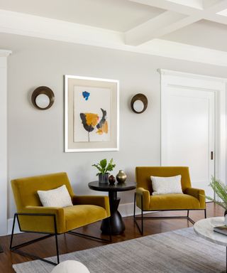 living room with off-white walls and mustard accent chairs