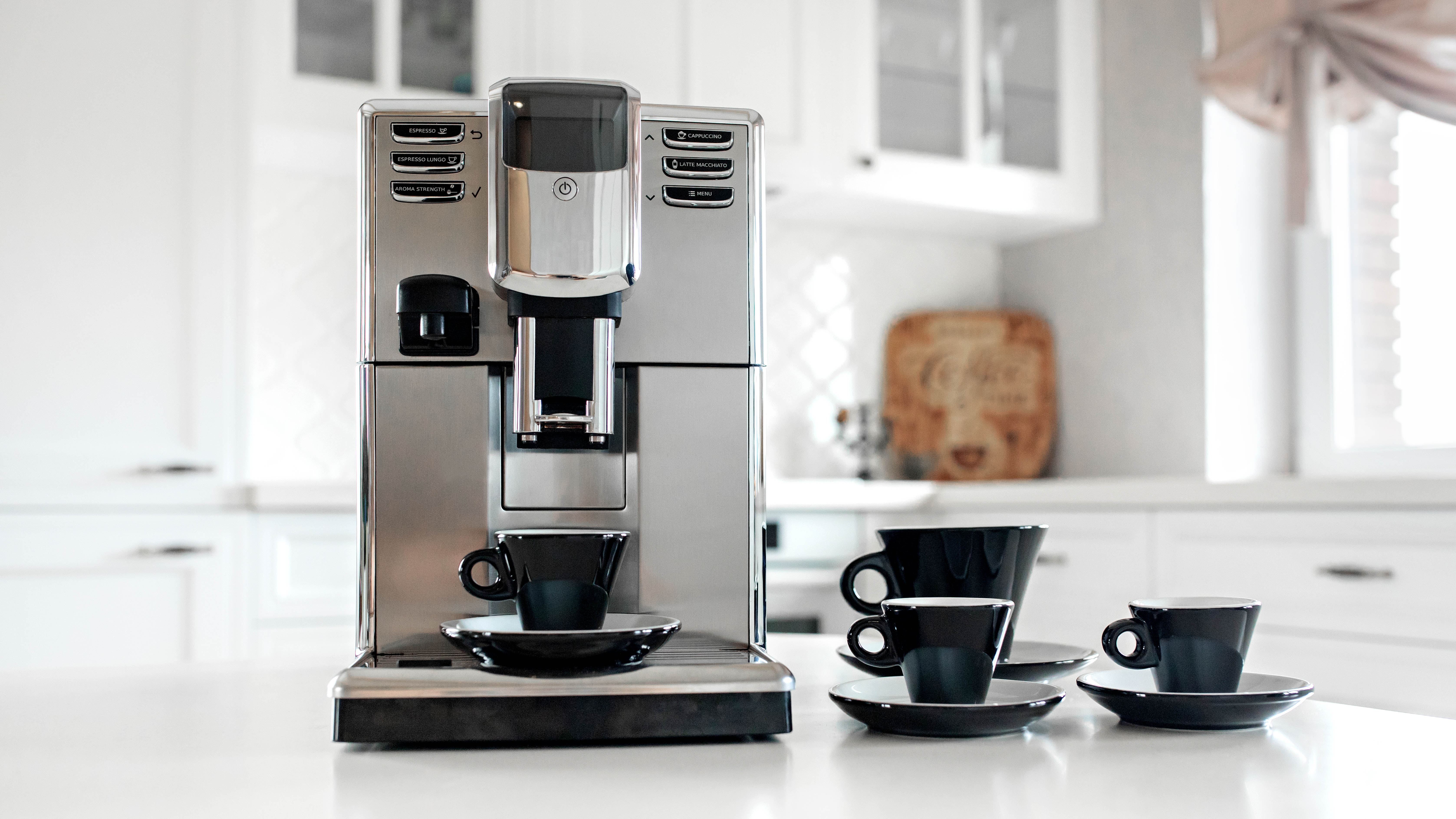 An espresso machine in a kitchen next to tea cups